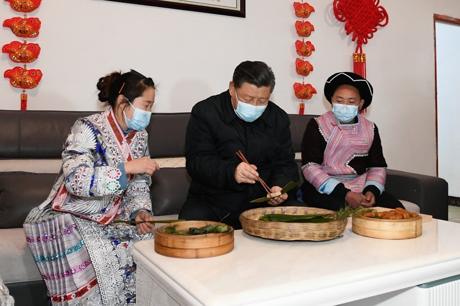 2021年2月3日下午，習(xí)近平在貴州畢節(jié)市黔西縣新仁苗族鄉(xiāng)化屋村苗族村民趙玉學(xué)家，同一家人邊聊家常邊制作當(dāng)?shù)貍鹘y(tǒng)節(jié)日食品黃粑。新華社記者 李學(xué)仁 攝