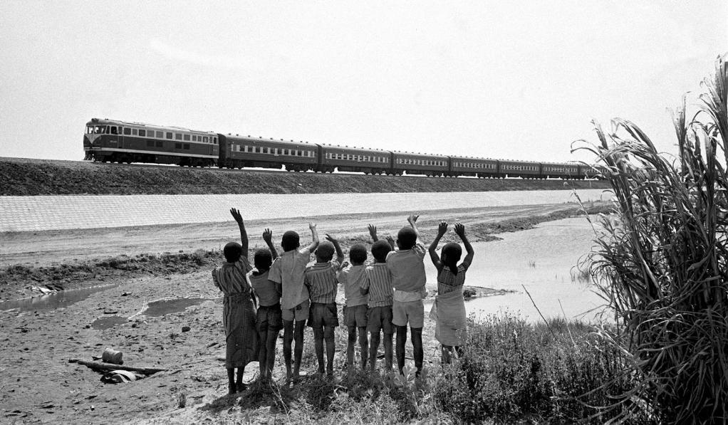 贊比亞魯西瓦西湖畔的少年兒童歡迎坦贊鐵路的列車(chē)通到他們的家鄉(xiāng)（1976年攝）。